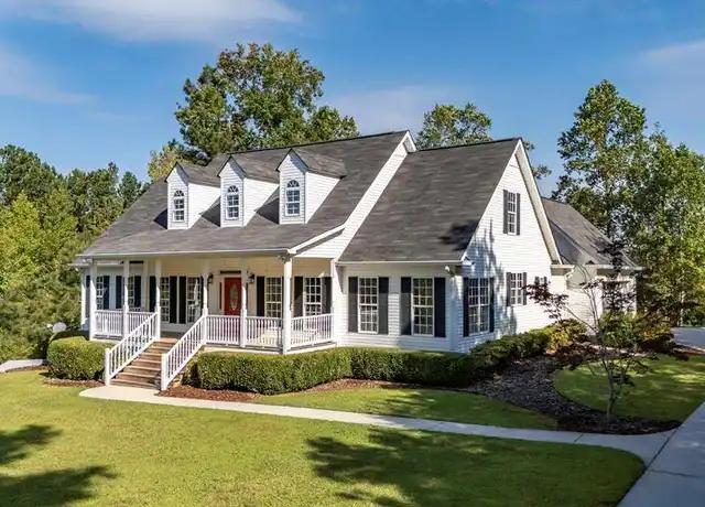 White home with black shutters and a red front door showcasing strong curb appeal